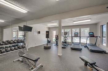 A gym with treadmills, weights, and exercise equipment.